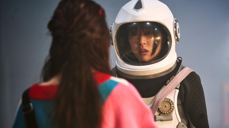 Joan (Kim Bo-ra) fait face à une femme alors qu'elle porte une combinaison spatiale dans SF8