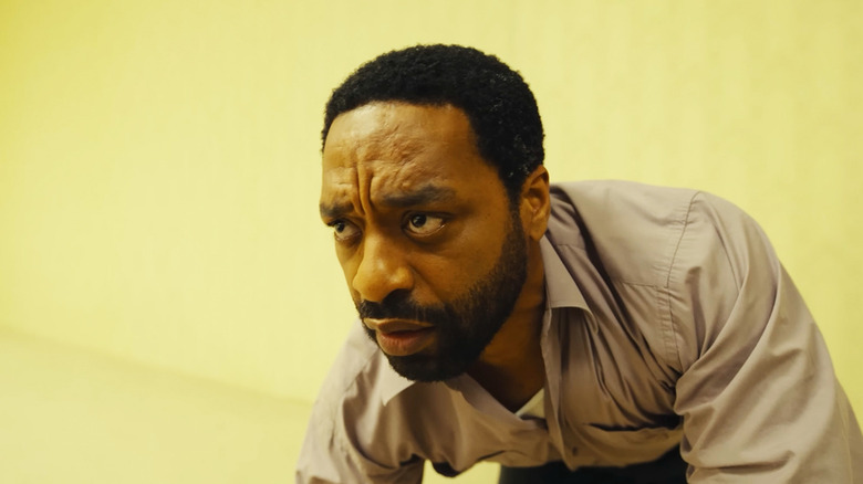 Chiwetel Ejiofor's Clark looks up as he crouches on all fours in Backrooms