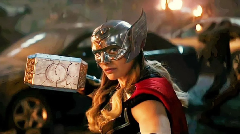 natalie portman as mighty thor holding thor's hammer in thor: love and thunder