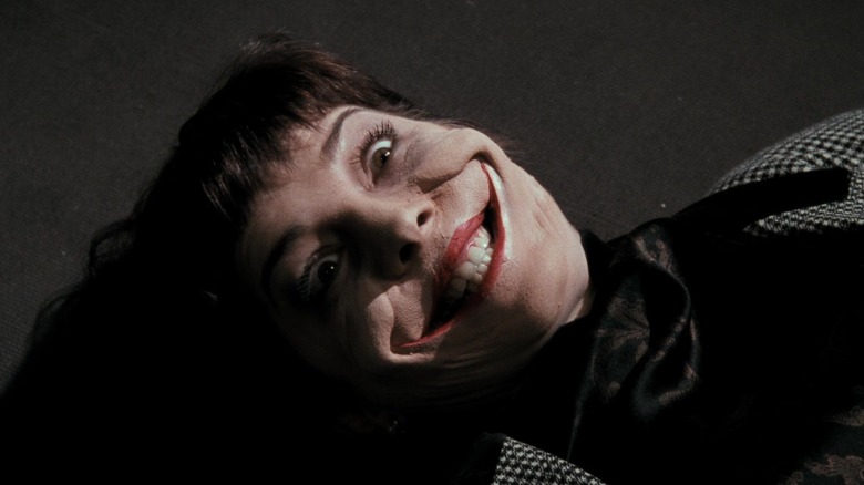 A newscaster, dead, with a Joker grin on her face in Batman