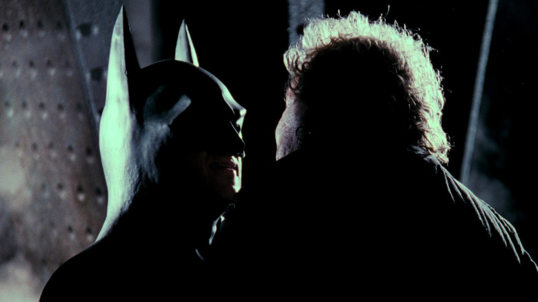 Batman holding up a criminal in Batman (1989)
