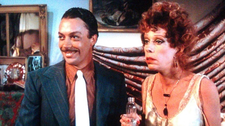 Rooster grinning and Miss Hannigan looking worried in Annie