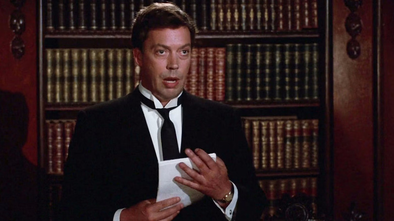 Wadsworth holding papers and talking in Clue