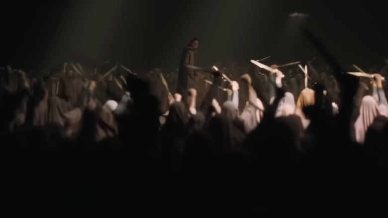 Paul standing in front of a cheering crowd in Dune: Part Two