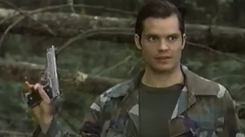 Scooby holding a gun in the woods in Mr. & Mrs. Smith