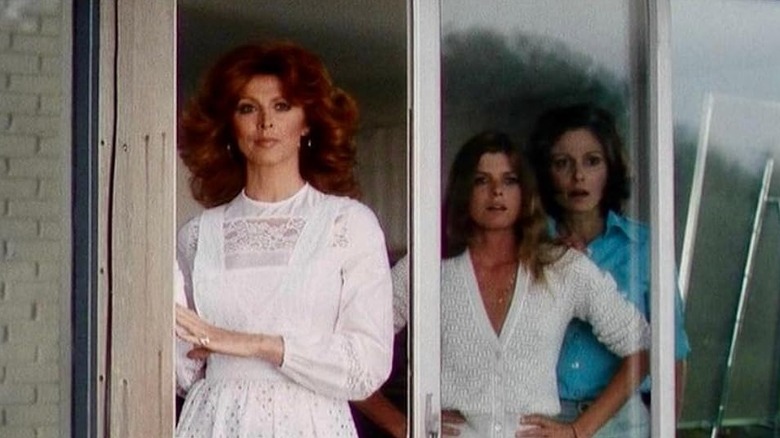 Chamaine, Joanna, and Bobbie looking through a patio door in The Stepford Wives