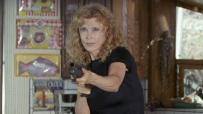 Tina Louise's Patricia Ludwigson aims a shotgun as she stands in her house in LA Heat