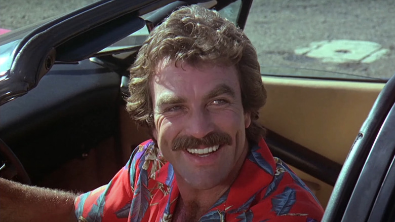Tom Selleck's Thomas Magnum smiling and wearing a Hawaii shirt on Magnum, P.I.