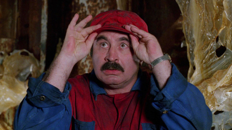 Bob Hoskins as Mario looking up in alarm in Super Mario Bros.