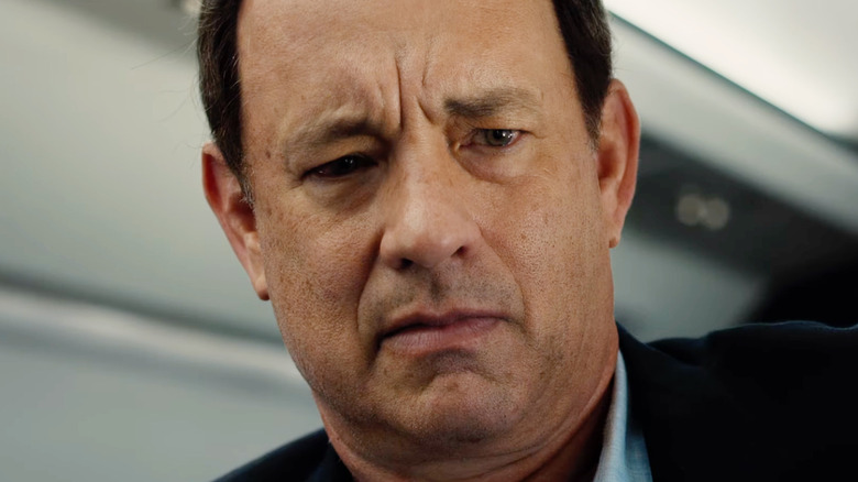Tom Hank as Robert Langdon looking concerned in an airplane in Inferno