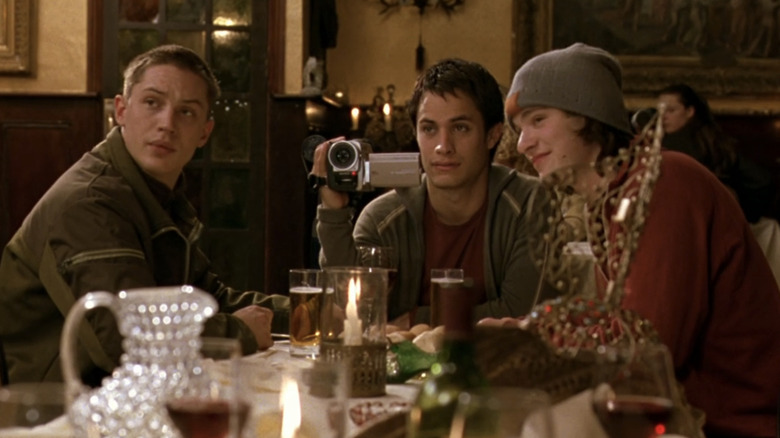 Gael García Bernal's Kit Winter sits between Tom Hardy's Tom and Charlie Cox's Theo at a restaurant in Dot the I