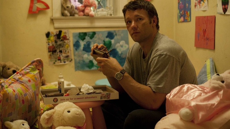Joel Edgerton sebagai Brendan memegang kamera di Warrior