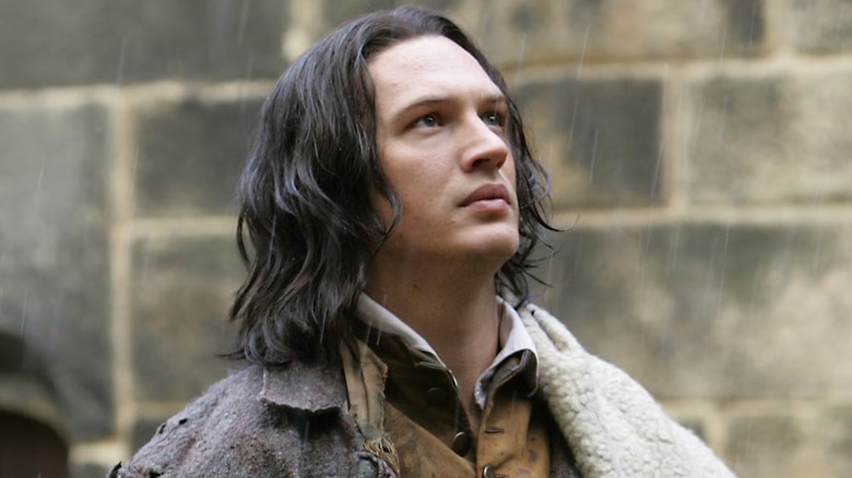 Tom Hardy stands in the rain as Heathcliff in Wuthering Heights