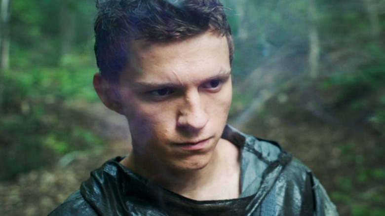 Tom Holland's Todd Hewitt is seen in closeup as he stands in the forest in Chaos Walking