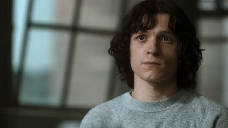 Tom Holland's Danny Sullivan sits in a room looking across frame in The Crowded Room