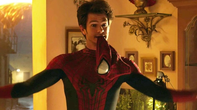 The Andrew Garfield version of Spider-Man, holding his mask in his teeth, in Spider-Man: No Way Home