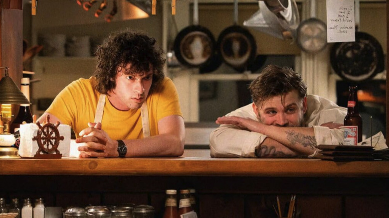 Tony and Sal leaning on the bar in the restaurant where they work in Tony