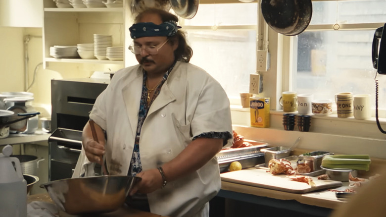Stavros stirring something in a bowl in the kitchen in Tony