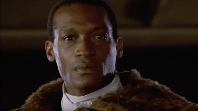 man in fur coat with bees in his open mouth