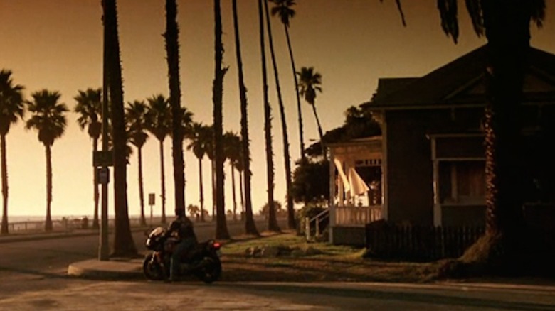 Tom Cruise as Pete "Maverick" Mitchell sits on a motorcycle outside of Charlie Blackwood's house in Top Gun