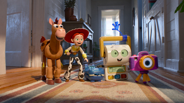 Joan Cusack as the voice of Jessie standing in a hallway next to Craig Robinson as Atlas, Conan O'Brien as Smarty Pants, and Shelby Rabara as Snappy in Toy Story 5