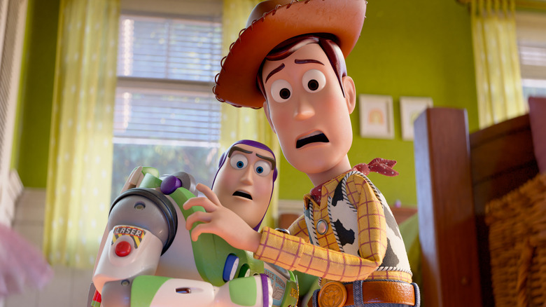 Tim Allen as the voice of Buzz Lightyear and Tom Hanks as the voice of Woody looking scared and standing in a child's bedroom in Toy Story 5