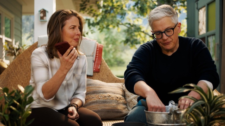 Robin Weigert as Teddi Bruin holds a smartphone as she talks with Abby McEnany as Velma Bruin in Tracker