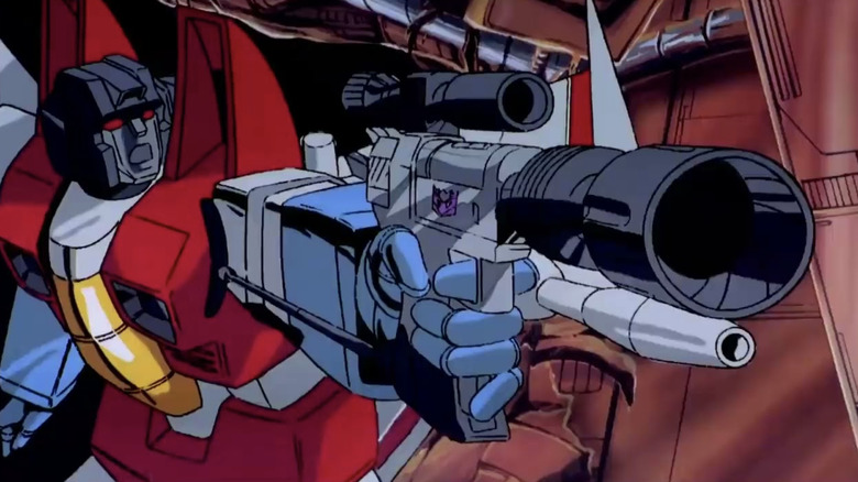 The Transformers: The Movie Starscream holding Megatron in gun mode