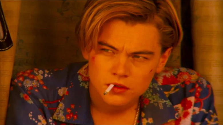 pensive blonde man with a cigarette in his mouth wearing a blue floral shirt