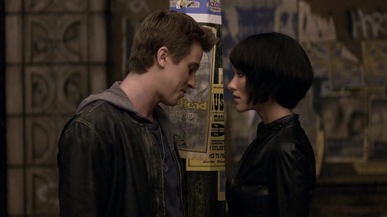 Sam (Garrett Hedlund) and Quorra (Olivia Wilde) stand face to face in Tron: Legacy