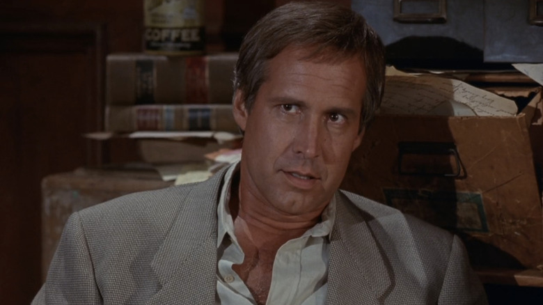 Chris Thorne de Chevy Chase semble confus alors qu'il est assis dans une salle d'audience dans Nothing but Trouble