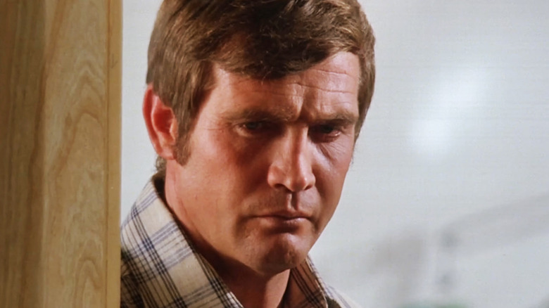 Lee Majors' Steve Austin is seen in closeup as he leans on a door frame in The Six Million Dollar Man