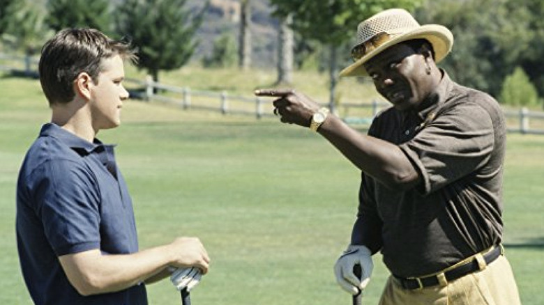 Bernie Mac, wearing a golf polo and hat, points a finger at Matt Damon, both holding golf clubs, in "The Bernie Mac Show"