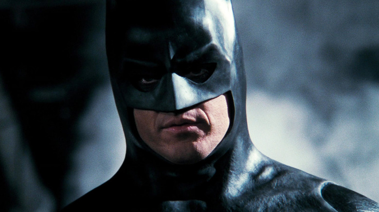 MIchael Keaton's Batman is seen in close-up against a smoky background in Batman