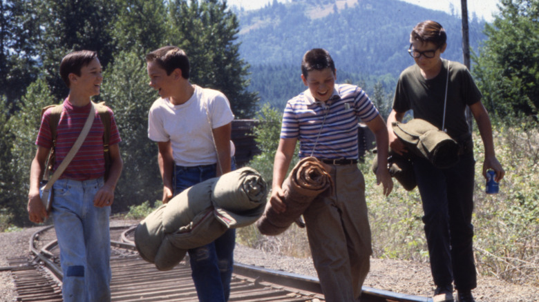 Wil Wheaton as Gordie, River Phoenix as Chris, Jerry O'Connell as Vern, and Corey Feldman as Teddy walking on the train tracks in Stand By Me