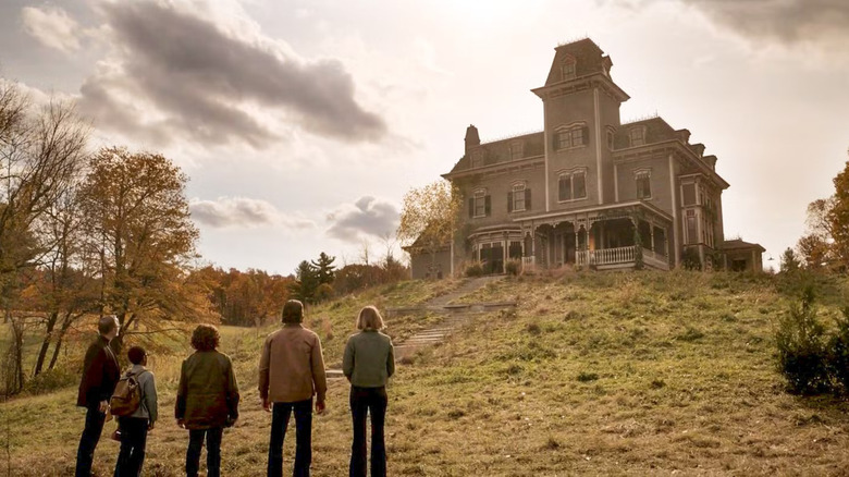Five people looking up at a creepy house in Salem's Lot