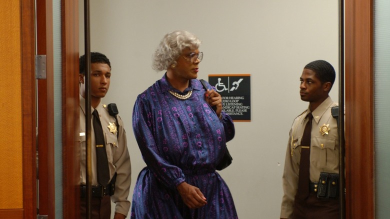 Madea Simmons (Tyler Perry) is escorted into a courtroom by two police officers in Madea's Family Reunion