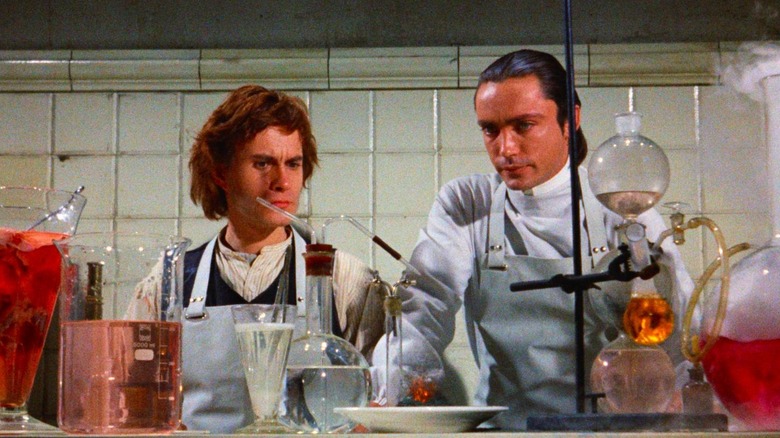 Otto and Baron Frankenstein at a table covered in beakers in Flesh for Frankenstein