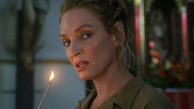 Oma Thurman as a dispute carrying a incense stick lit in the old guard 2