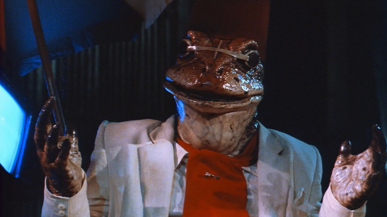 A frog in a white suit shows his hands in Hell Comes to Frogtown