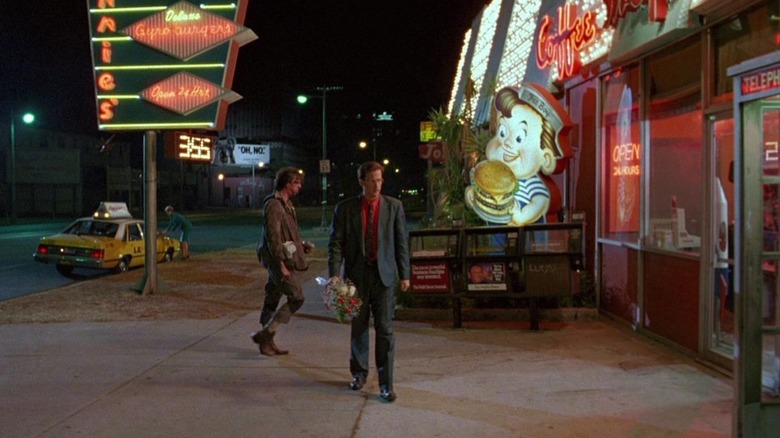 Harry Washello (Anthony Edwards) walks down the sidewalk by a restaurant in Miracle Mile