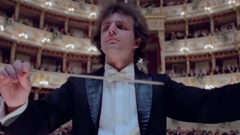 Conductor in front of the orchestra in Opera (1987)