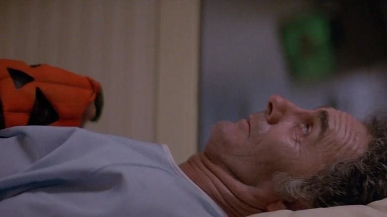 Man holding a pumpkin Halloween mask in Halloween III: Season of the Witch