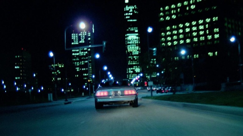 Car driving down streets at night