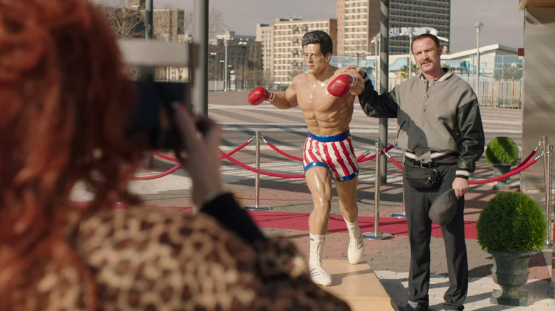 Liev Schreiber next to Rocky statue