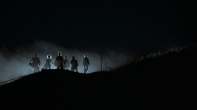 Band of vampires standing atop a hill
