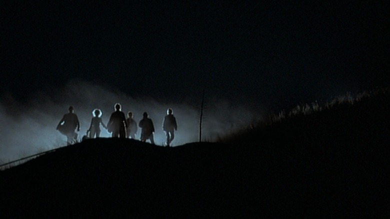 Band of vampires standing atop a hill
