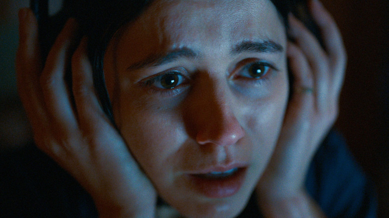 Evy holds her headphones tight in undertone