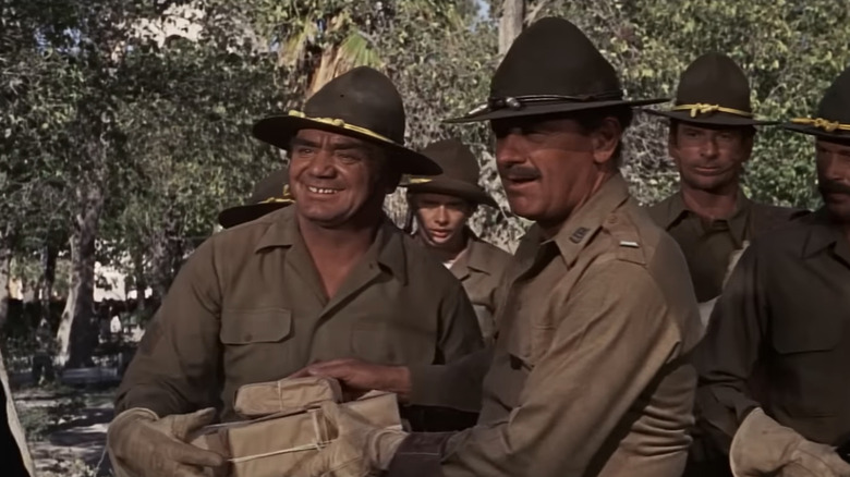 De Nederlandse Engstrom van Ernest Borgnine houdt een pakje vast terwijl hij naast William Holden's Pike Bishop in The Wild Bunch staat