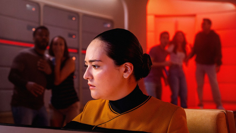 Fans watch as a Starfleet officer works the controls in Star Trek: Red Alert